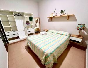 a bedroom with a bed with a striped bedspread at Verde Limón - Casa compartida in San Salvador de Jujuy