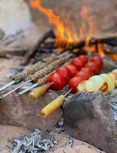 a group of hot dogs and carrots next to a fire at Star Magic Camp in Wadi Rum