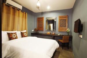 um quarto com uma cama e uma secretária com um espelho em Lilu Chiang Mai em Chiang Mai