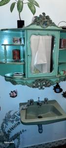 a bathroom with a green sink and a mirror at Habitación 4 en Casa Retro in Medellín