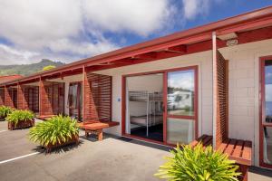 a house with a porch with benches and plants at Nelson City TOP 10 Holiday Park in Nelson