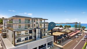 特里格尔Oceans Edge #7 Accom Holidays的背景中带有海洋的建筑的形象