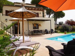 eine Terrasse mit Stühlen und Sonnenschirmen neben einem Pool in der Unterkunft Mas Nuria - L'Estartit, Torre Vella - ES-323-33 in L'Estartit