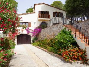 ein weißes Haus mit einem Tor und Blumen in der Unterkunft Mas Nuria - L'Estartit, Torre Vella - ES-323-33 in L'Estartit