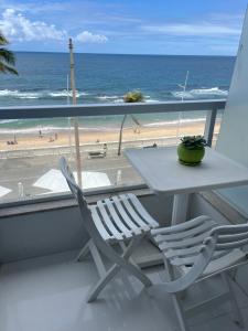 a table and chairs on a balcony with a view of the beach at Bahia Flat ap 206 in Salvador