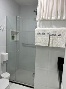 a bathroom with a shower and a toilet and a towel at Bahia Flat ap 206 in Salvador +10 photos