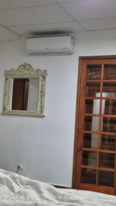 a bedroom with a window and a mirror and a bed at Hostel Paz&Saúde in Goiânia
