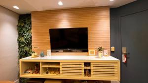 a flat screen tv on a wooden wall at Lindo flat na Sena Madureira! (Apto 1305) in São Paulo