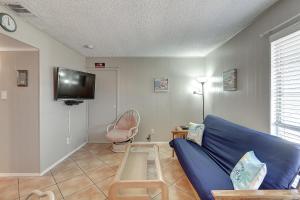 a living room with a blue couch and a tv at Mustang Bungalow 4MI in Port Aransas