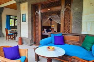 a living room with a blue couch and a table at Gitali 1 BR Superior Garden View ZN244 in Ubud