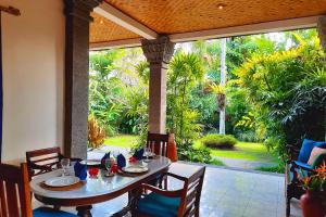 a dining table and chairs on a patio at Gitali 1 BR Superior Garden View ZN244 in Ubud