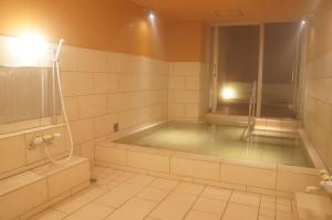 a bath tub in a bathroom with a shower at Hotel Abest Hakuba Resort in Hakuba