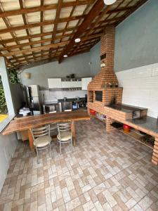 a kitchen with a table and chairs and a brick oven at Casa em cidade Histórica in Caxambu