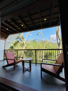 a room with two chairs and a table on a balcony at Lush Acres in Thekkady +63 photos