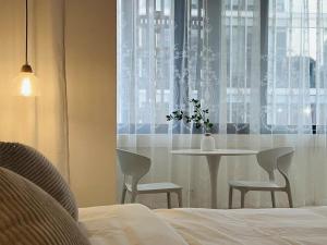 a bedroom with a table and chairs and a window at WillsChengduCenter in Chengdu