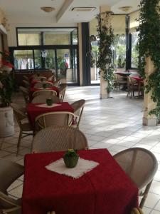 een restaurant met tafels en stoelen met rode tafellakens bij Hotel Dall'Ara in Villa Marina