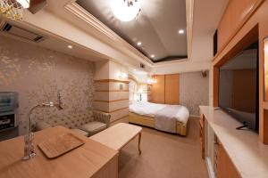 a hotel room with a bed and a television at Hotel Luna Sendai -Adult Only in Shimo-ayashi
