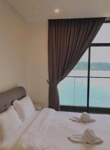 a bedroom with a bed with a large window at SummerSet Seaview Studio Apartment at Kota Kinabalu City Centre in Kota Kinabalu
