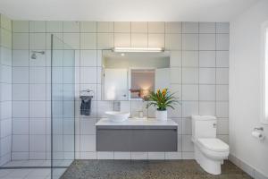 a bathroom with a toilet and a sink and a mirror at Blue Seas in Lennox Head