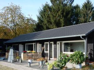 a small house with tables and chairs in front of it at De Rolders in Wapenveld