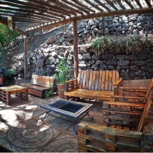 a patio with two benches and a stone wall at Cabaña Rústica Piedra y Viento in San José de Maipo