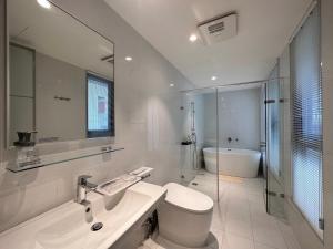un bagno bianco con un water e un lavandino di Yama no Shita Homestay a Zhongpu