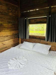a white bed in a room with a window at Khu Nghỉ dưỡng Sinh thái Nhà Lụa Retreat in Ấp Quảng Giáo +1 photo