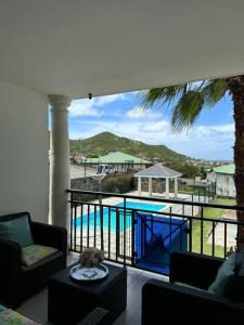 a balcony with a view of a swimming pool at Chermakish Exceptional View Logement 3 Chambres, Piscine in Marigot