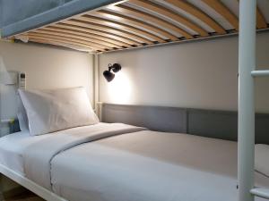 Postel nebo postele na pokoji v ubytování Minimalist and Cozy 2BR at La Hub City Apartment By Travelio