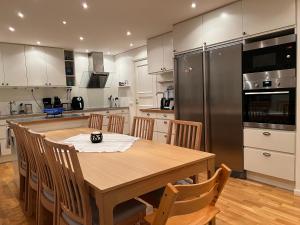 a kitchen with a wooden table and a stainless steel refrigerator at Villa LakePlats in Östersund
