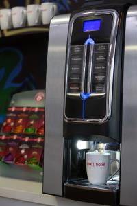 una macchinetta del caffè con una tazza di caffè di mk hotel berlin a Berlino