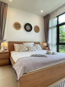 ein Schlafzimmer mit einem Bett und zwei Uhren an der Wand in der Unterkunft Forest Hill Residences Koh Samui Villa Alaia 3bd, 5 min walking from Fishermans Village in Koh Samui 
