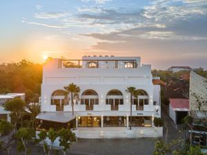 un edificio blanco con la puesta de sol en el fondo en Two Palms Bingin, en Uluwatu