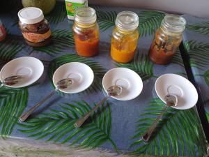 a table topped with spoons and jars of jam at Pitake Lodge 1 in Nuku Hiva +6 photos