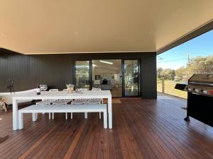 Una sala de estar con una mesa blanca y una parrilla. en Golden Beach Beauty!, en Paradise Beach
