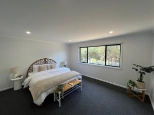 Un dormitorio con una cama grande y una ventana. en Golden Beach Beauty!, en Paradise Beach