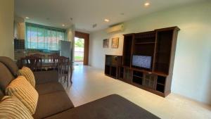 a living room with a couch and a flat screen tv at Seaview Condominium A12 in Ban Tha Fat