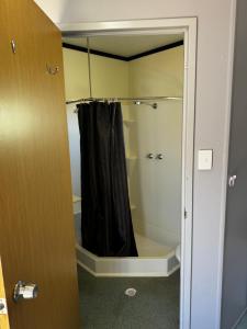 a shower with a black shower curtain in a bathroom at Summer Port Lodge in Port Hedland +10 photos
