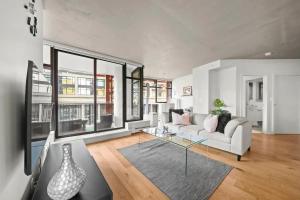 a living room with a white couch and a glass table at Modern Condo in downtown two bedroom parking lot in Vancouver