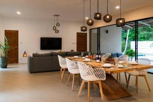 a dining table and chairs in a living room at Secret Villa Koh Phangan in Koh Phangan