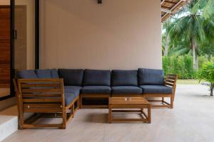 a blue couch and two chairs and a table at Secret Villa Koh Phangan in Koh Phangan