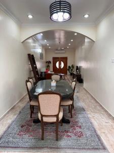 a dining room with a table and chairs on a rug at Rumah Mawar in Arau