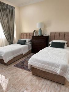 a bedroom with two beds and a dresser at Rumah Mawar in Arau
