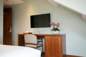 een slaapkamer met een bureau, een tv en een stoel bij Pierr Palace Hotel (Beijing Nanluo Guxiang) in Beijing +27 foto's