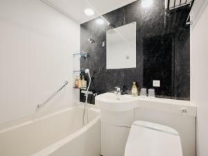 东京hotel MONday Haneda Airport的浴室配有卫生间、盥洗盆和浴缸。