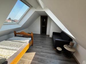 Zimmer im Dachgeschoss mit einem Bett und einem Sofa in der Unterkunft Casa Andrea 4 Zimmer Wohnung in Wallersdorf