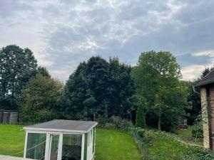 a greenhouse in the yard of a house at Gemütliche Appartement 4 - mit Küche und Bad zur Eigennutzung -Schuster Homes- in Alvesse