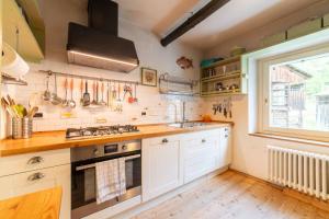 a kitchen with white cabinets and a window at La Casa dei Botiri in Rocca Pietore