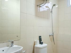 a bathroom with a shower and a toilet and a sink at Comfortable and Tidy 2BR at Vida View Apartment By Travelio in Pampang +24 photos