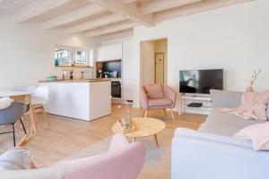 a living room with white furniture and a kitchen at Reihe 7 in Kappeln